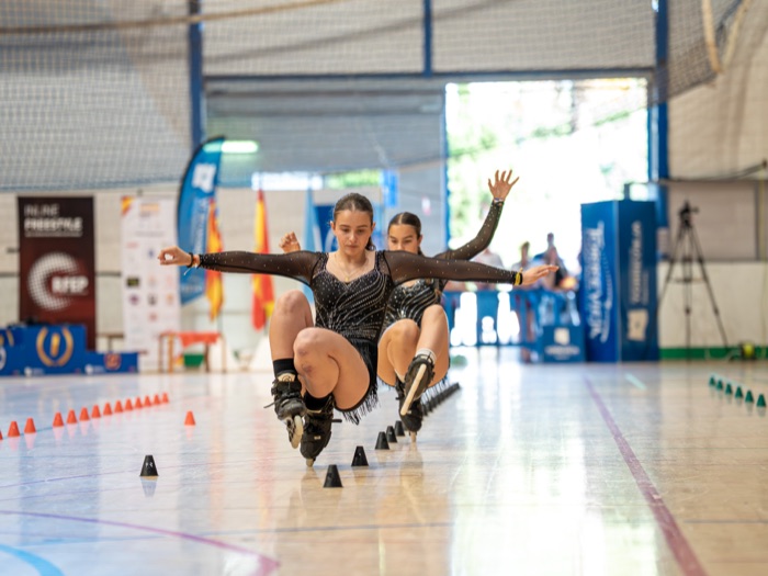 Dos patinadoras de Onskates con vestidos negros a juego ejecutando una coreografía sincronizada de Classic Slalom Parejas