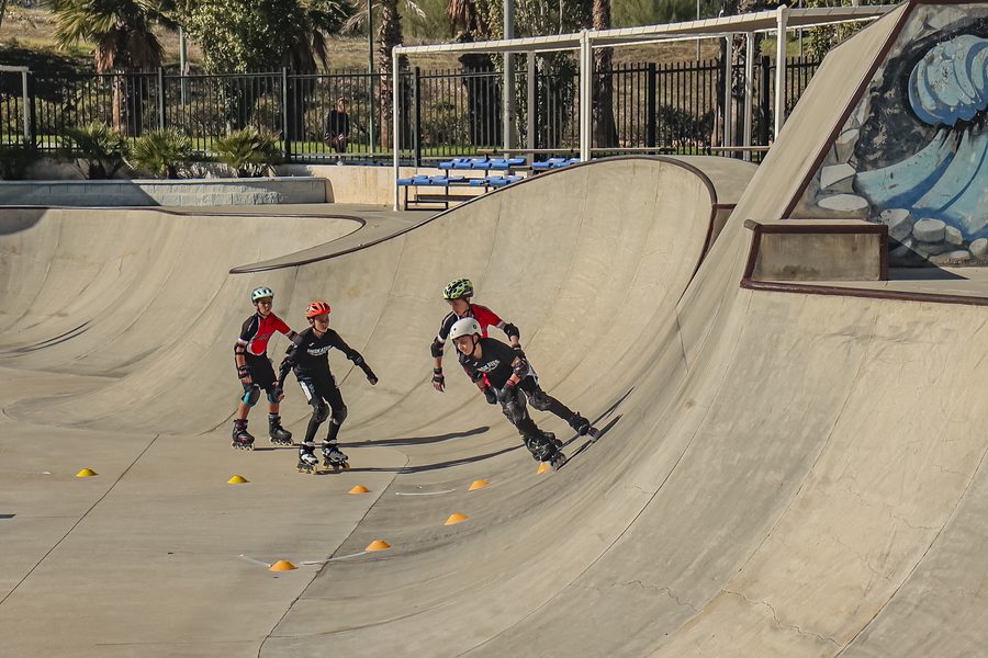 Cuatro patinadores del Team Onskates compitiendo codo con codo sobre una rampa en una prueba de Team Cross